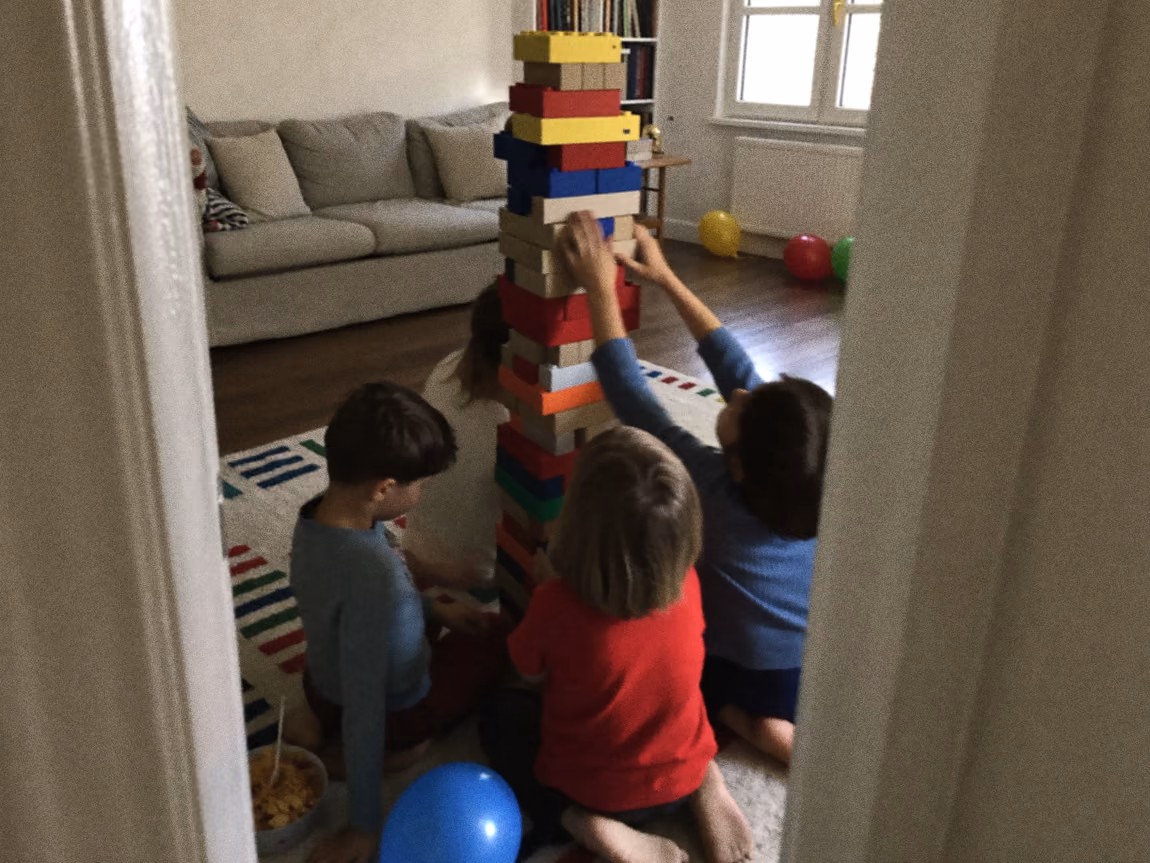 Kinderen spelen op de grond met gekleurde blokken tijdens een kinderfeestje thuis