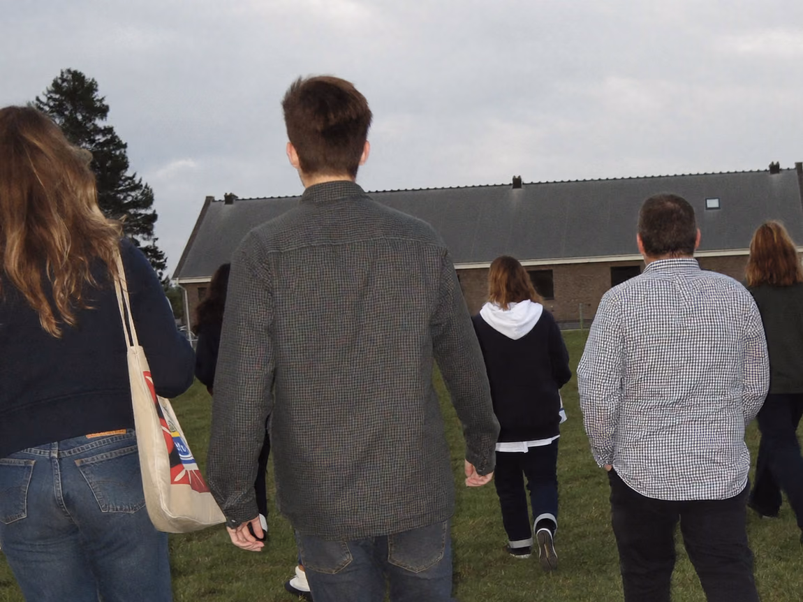 Collega's lopen samen over een veld tijdens een personeelsuitje