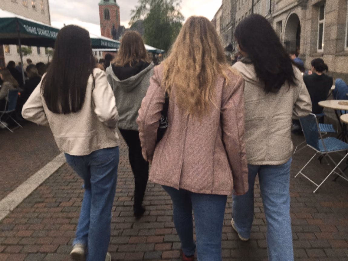 Vriendinnen lopen gearmd door een straat in Enschede tijdens een vrijgezellenfeest